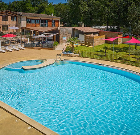 Bathing areas with sunbeds and parasols at our water park on Le Chêne Vert campsite, near Gaillac