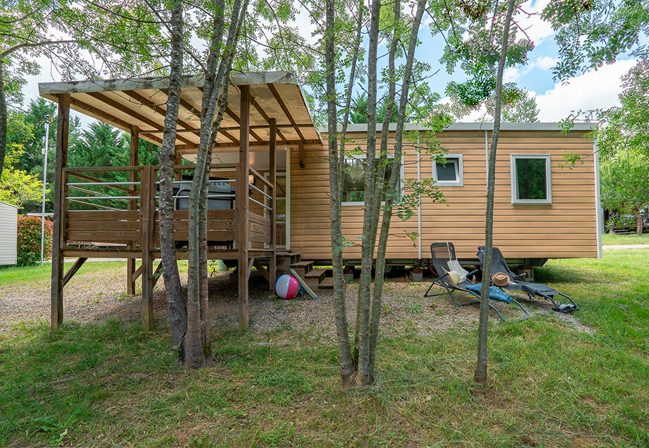 La terrasse couverte équipée de mobilier de jardin du mobil-home 6 personnes Premium 3 chambres, dans le Tarn, du camping 4 étoiles le Chêne Vert